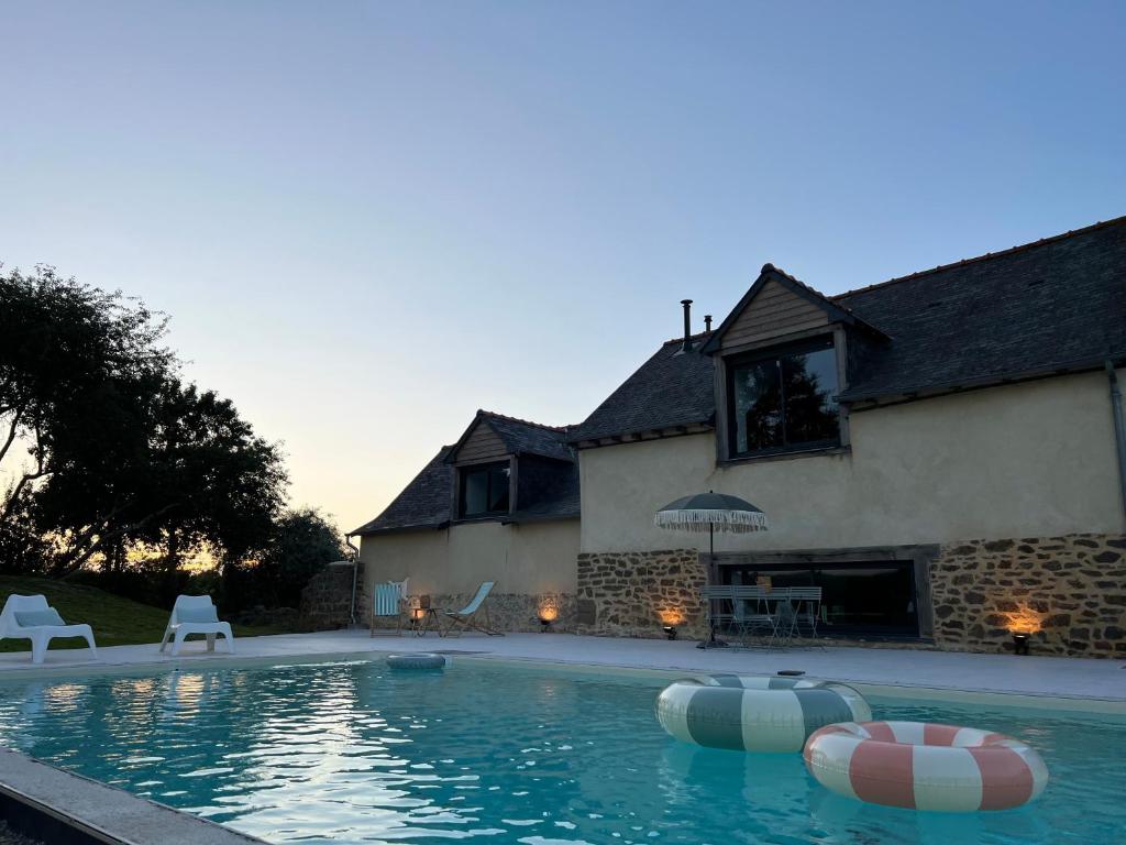 una piscina frente a una casa en Le Logis de la Lettre, en Tinténiac