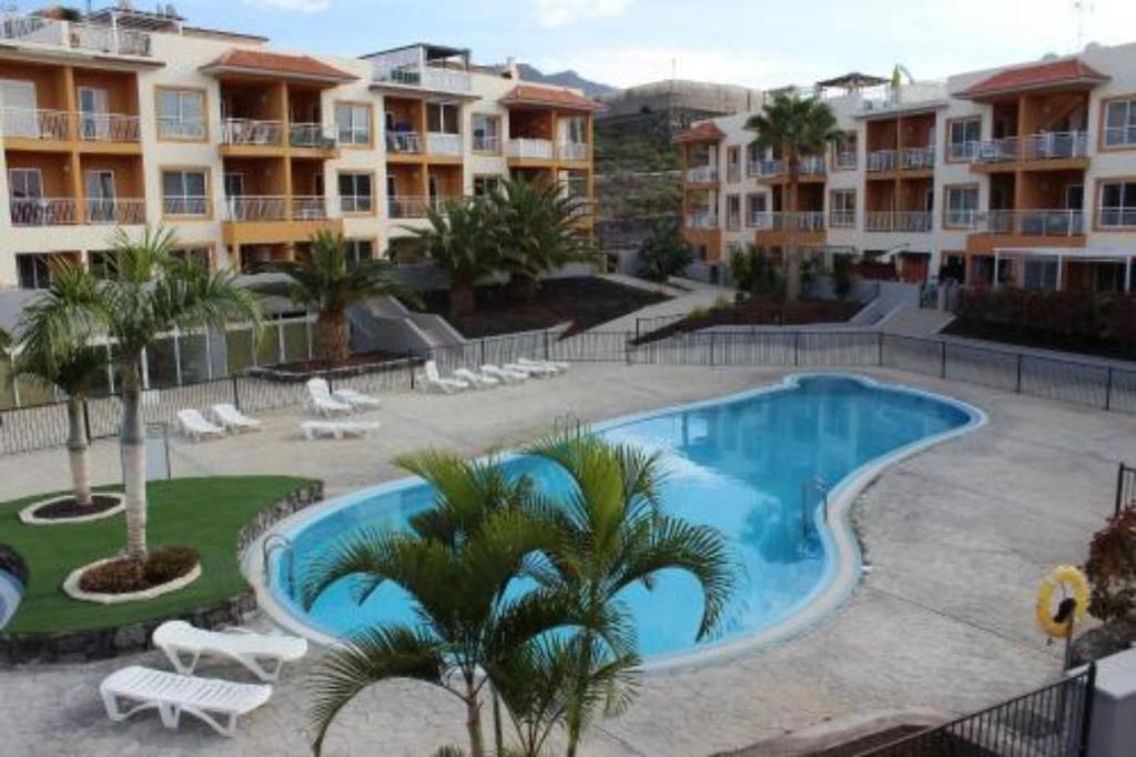 una piscina con palme e edifici di Fantastic View - Callao Salvaje Tenerife South a Callao Salvaje