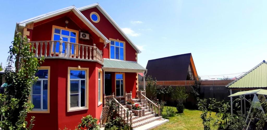 a red house with a balcony on top of it at Villa ELO in Kebele in Gabala