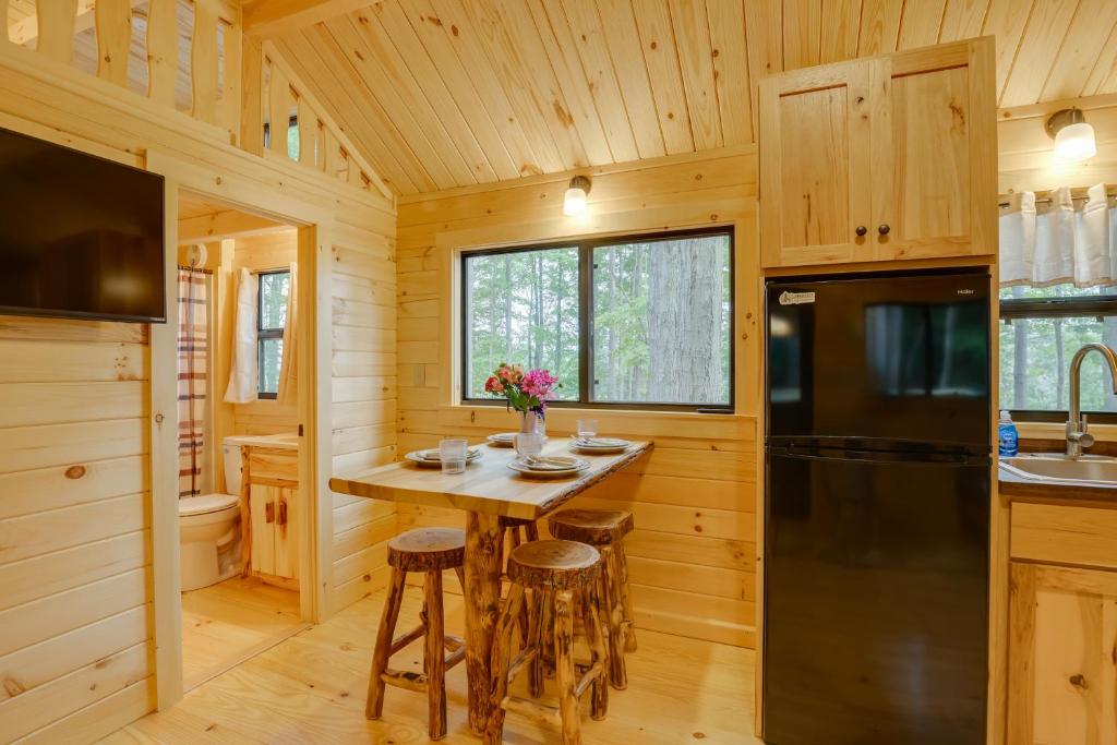 eine Küche mit einem Tisch und einem Kühlschrank in der Unterkunft Tranquil Middlebury Center Cabin with Mountain Views 
