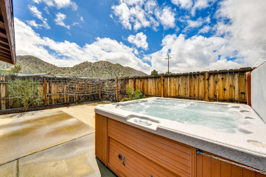 uma banheira de hidromassagem num quintal com uma cerca de madeira em Rural California Getaway with Private Hot Tub em Pioneertown