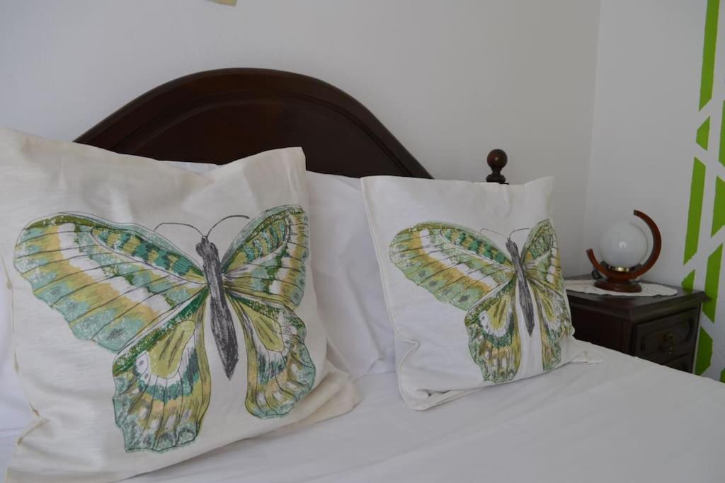 dos almohadas de mariposa sentadas encima de una cama en OrlaBela, en Manta Rota