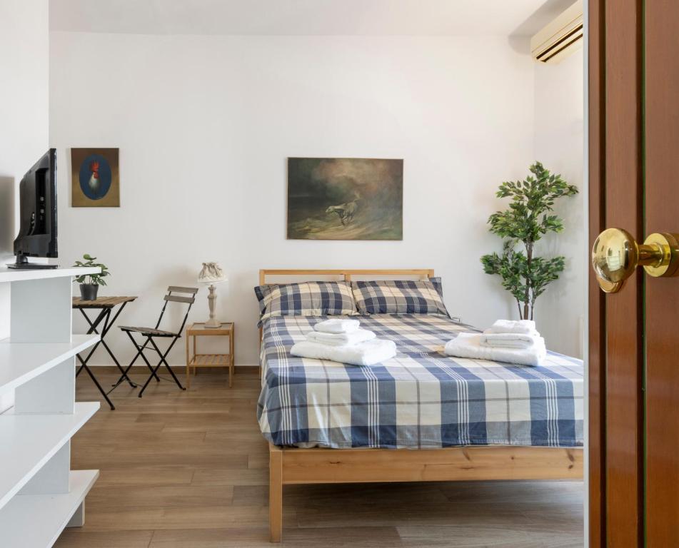 a bedroom with a bed with a blue and white blanket at Loft Corso Trieste in Bari