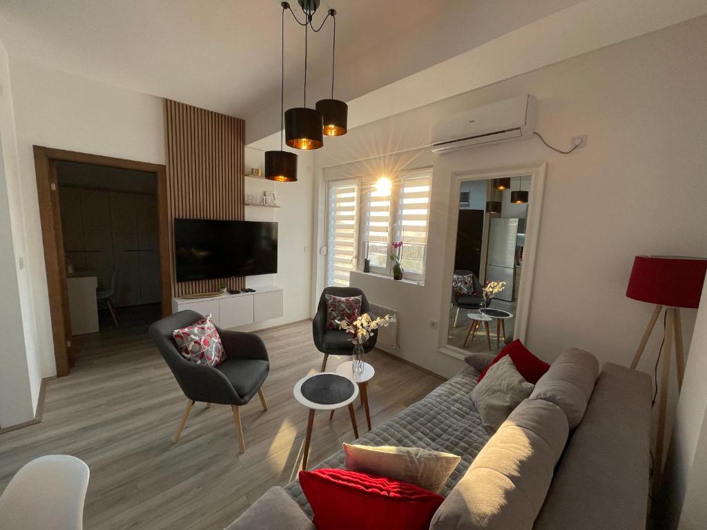 ein Wohnzimmer mit einem Sofa und Stühlen in der Unterkunft R Lux Apartman Jagodina Akva Park in Jagodina