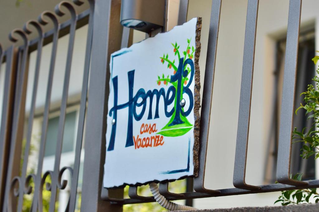 a sign on a fence with a home on it at Home 13 in San Gregorio di Catania