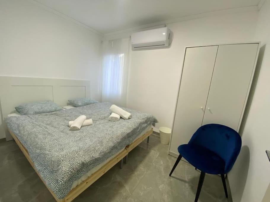 a bedroom with a bed and a blue chair at מצפה הכינרת in Safed