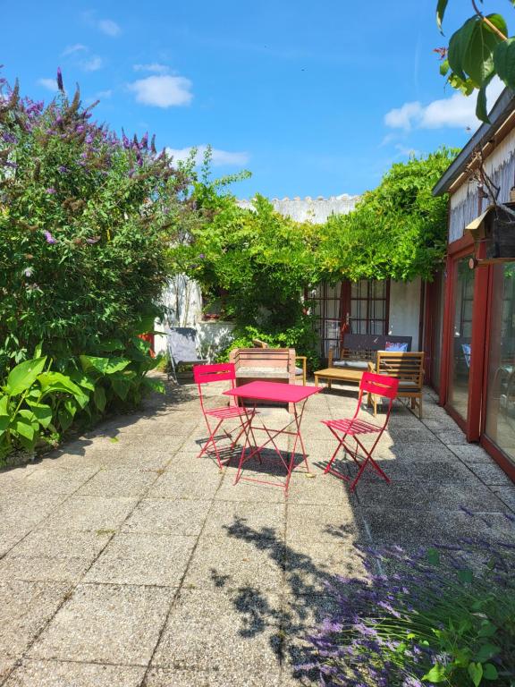 un grupo de sillas y una mesa en un patio en La maison rouge paisible maison de pays en Saujon