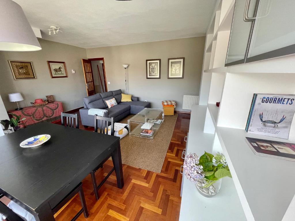 sala de estar con mesa y sofá en Precioso duplex en Nigrán, en Nigrán