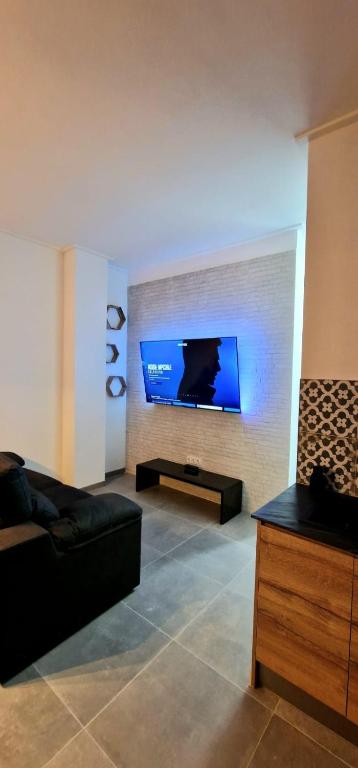 a living room with a couch and a flat screen tv at Loft el Baix - Cullera in Cullera