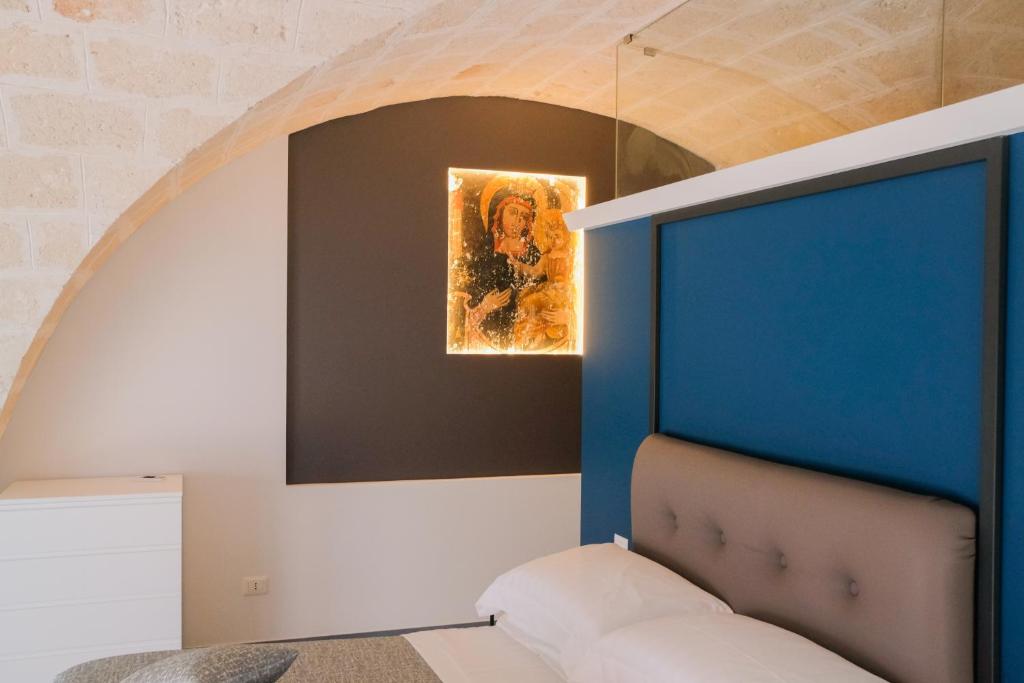 um quarto com uma cama azul e um quadro em Suite Polignani by STHEY em Monopoli