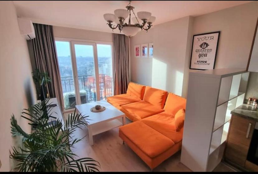 een woonkamer met een oranje bank en een tafel bij Kagıthane Gulmahal Residance 1+1 in Istanbul