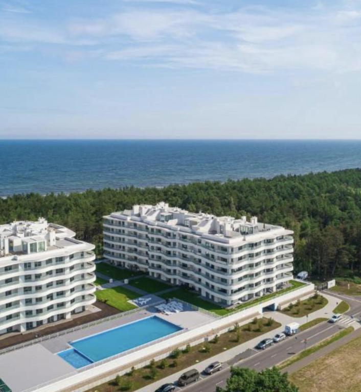 widok z powietrza na dwa duże białe budynki i ocean w obiekcie Sunrise Apartament w Rogowie