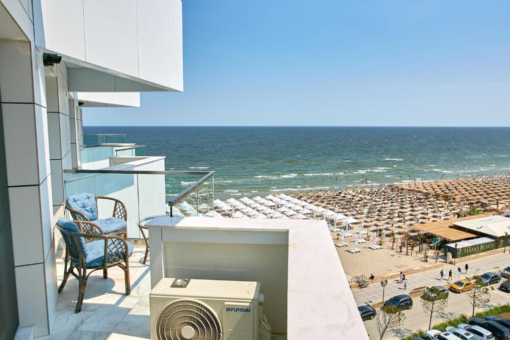 a balcony with a view of a beach and the ocean at Unique Sea View Infinity Pool & Spa in Mamaia Nord