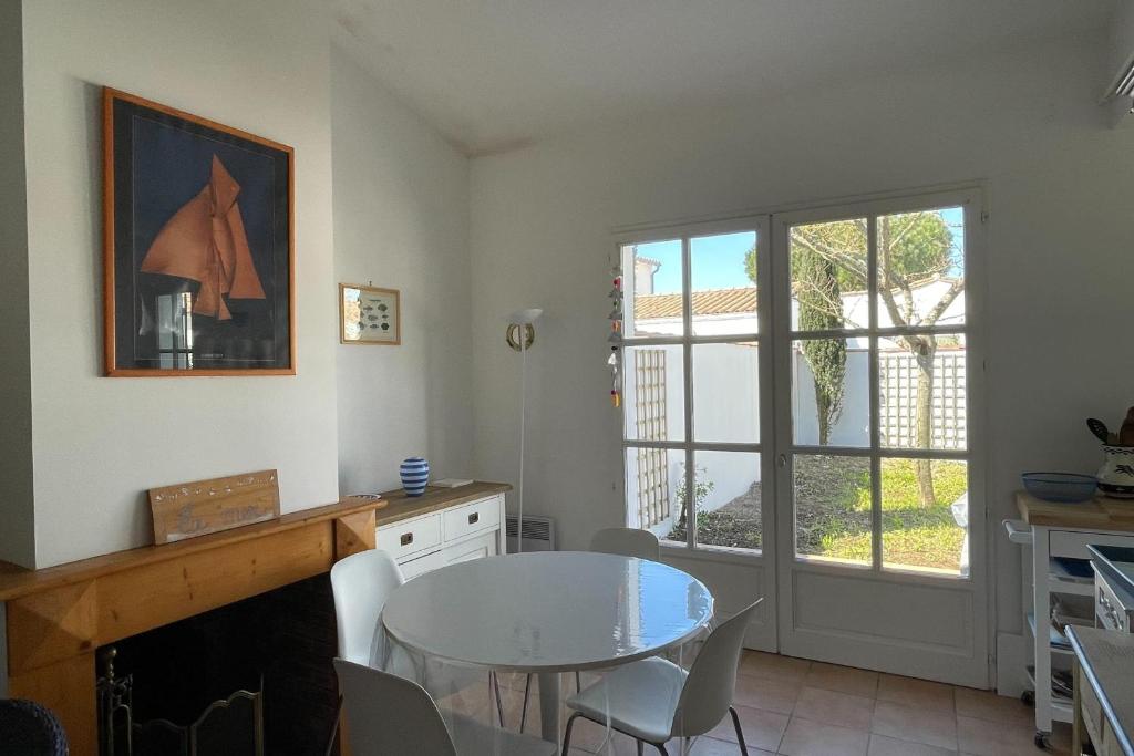 une cuisine avec une table et une salle à manger avec une fenêtre dans l'établissement 75m near the beach with garden and terrace, à La Flotte