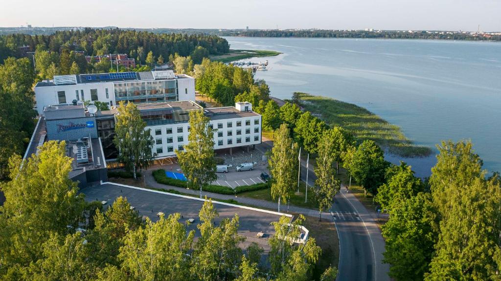 widok z powietrza na budynek obok wody w obiekcie Radisson Blu Hotel Espoo w mieście Espoo