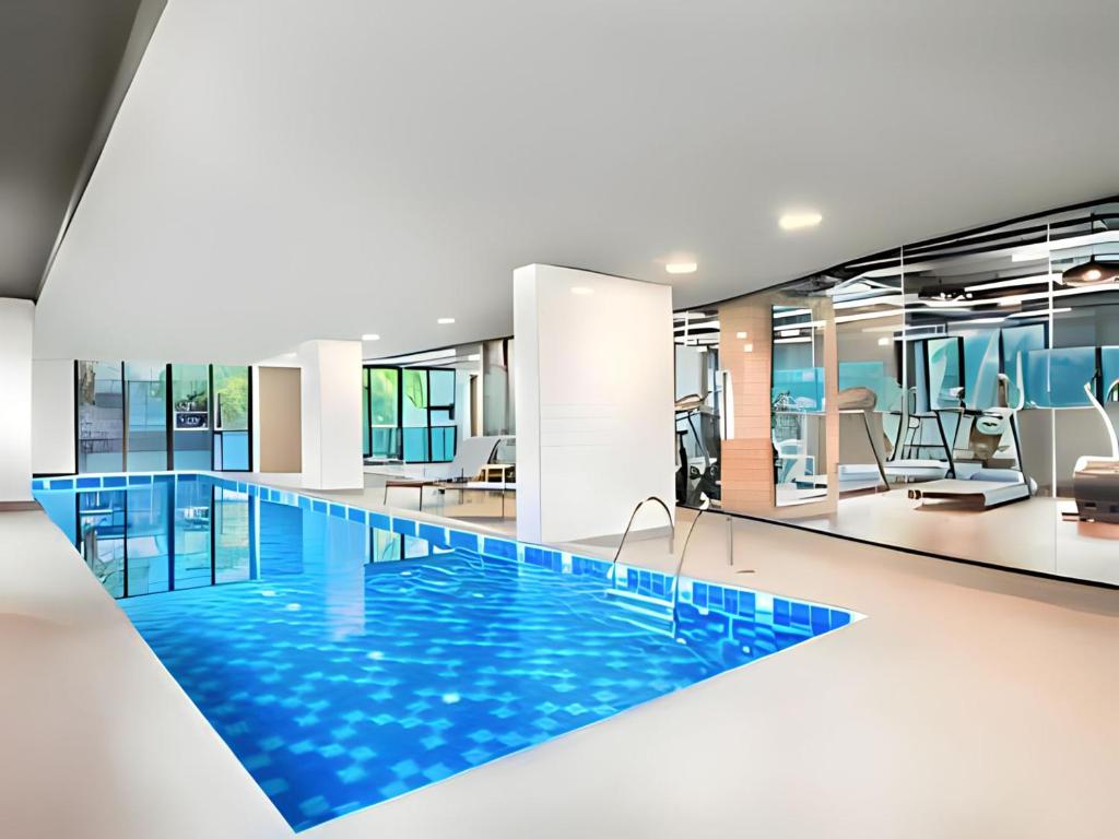 una piscina en una habitación de hotel con agua azul en Suíte 5 estrelas Hotel Av Ibirapuera 2534 Piscina, en São Paulo