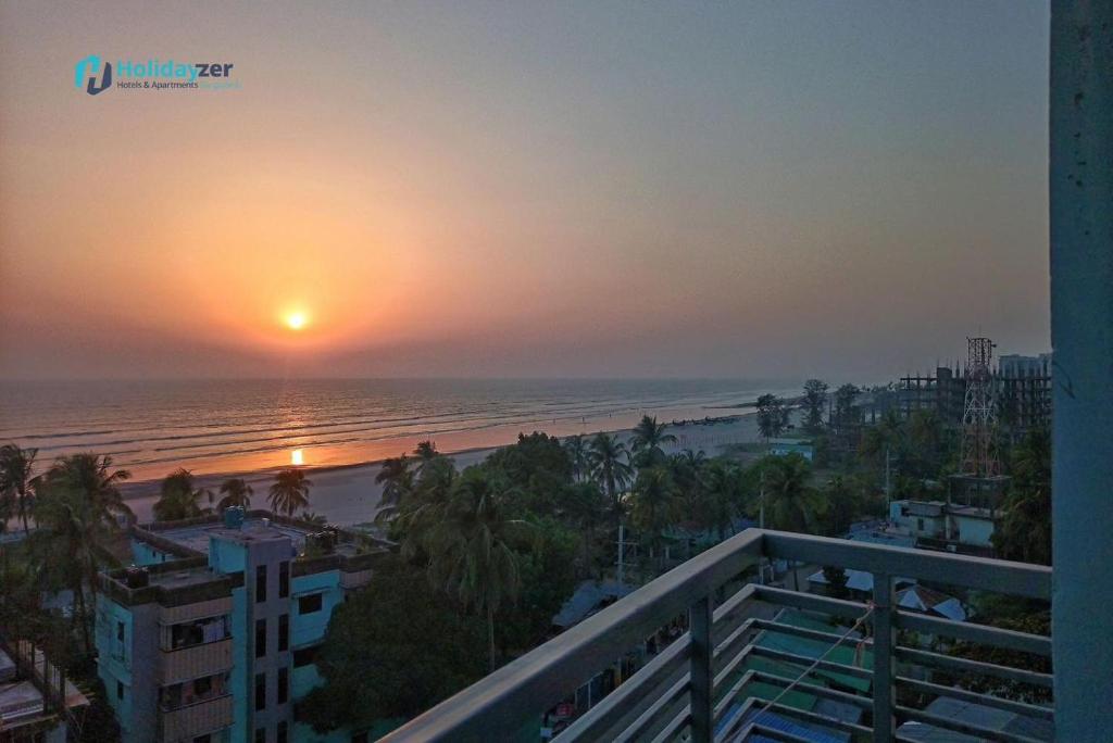 a view of the beach at sunset from the balcony of a condo at Modern Resort in Cox's Bazar