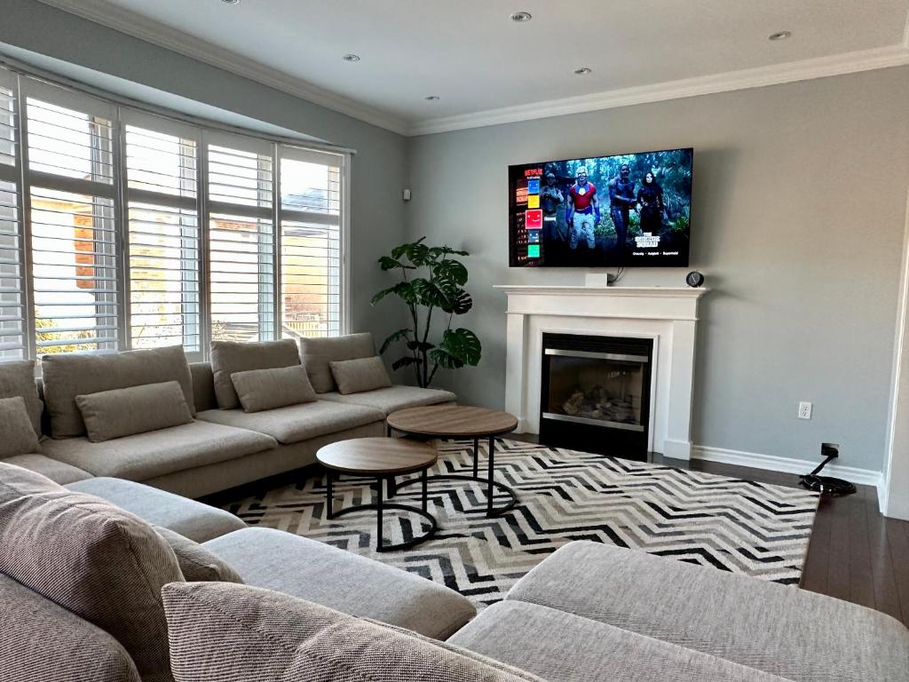 a living room with a couch and a fireplace at Cozy 5 Bedroom House Mississauga in Mississauga