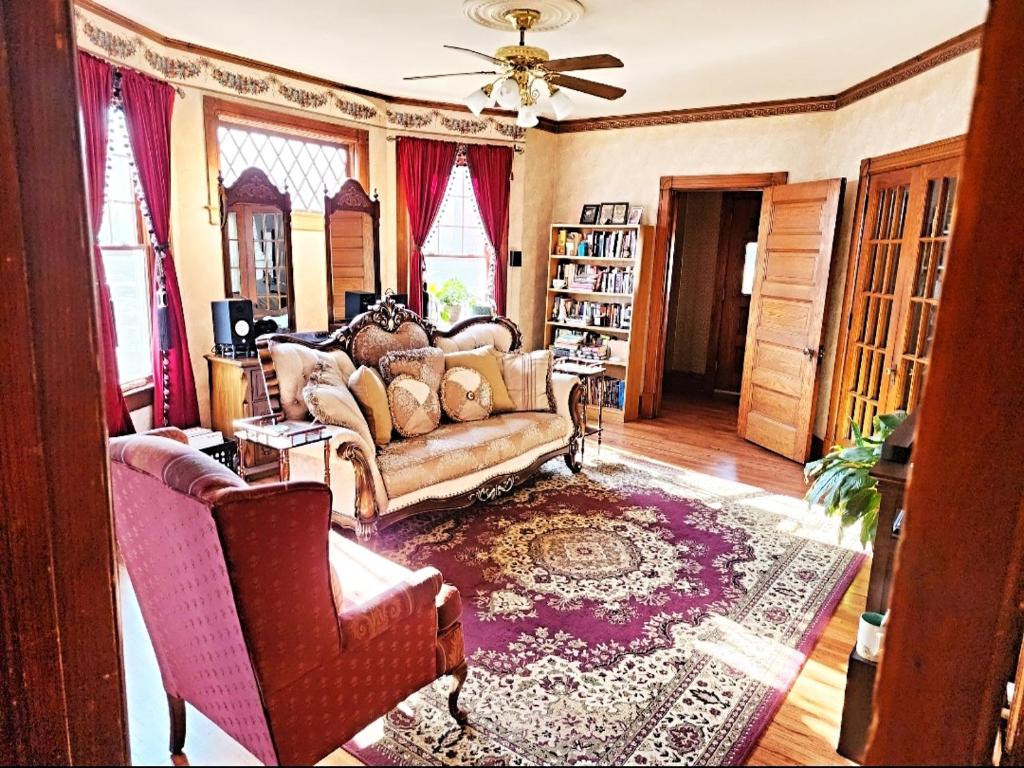 uma sala de estar com um sofá e duas cadeiras em Cozy Victorian w/4-Car Garage! em Omaha