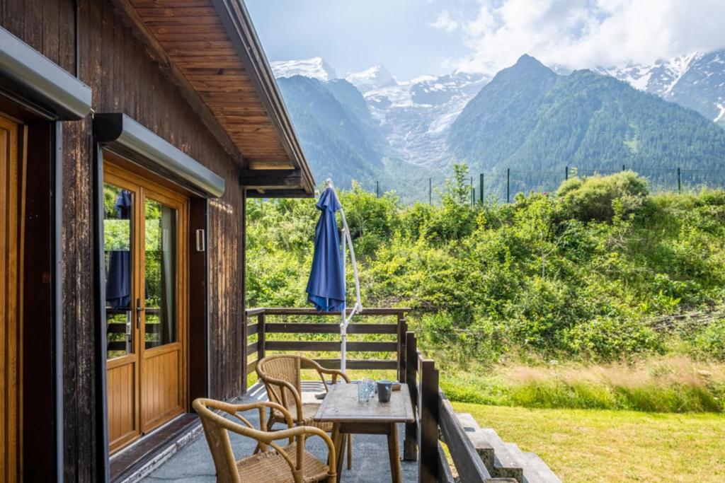 une terrasse avec une table, des chaises et un parasol dans l'établissement Rustic chalet with garden in Chamonix, à Chamonix-Mont-Blanc
