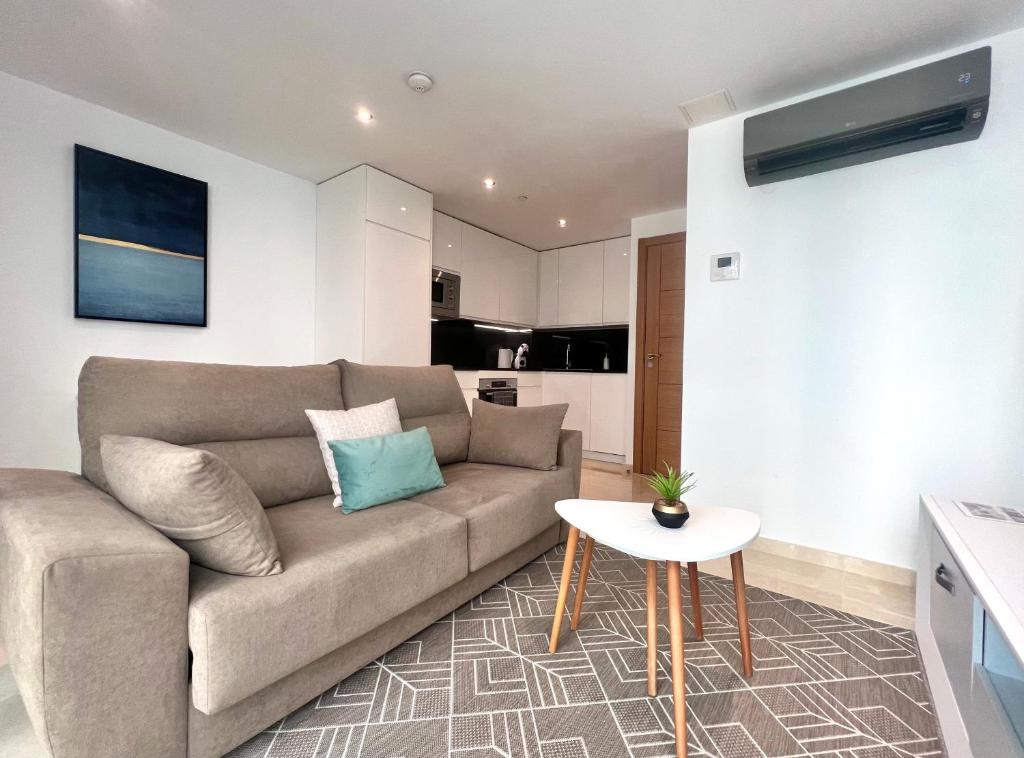 ein Wohnzimmer mit einem Sofa und einem Tisch in der Unterkunft Luxury 1 Bed Apt - City Suites Ocean Spa Plaza in Gibraltar