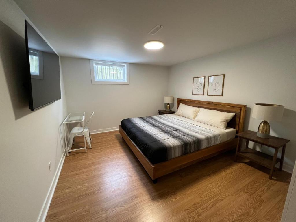 a bedroom with a bed and a television on the wall at Letitia Heights !B Spacious and Quiet Private Bedroom with Shared Bathroom in Barrie