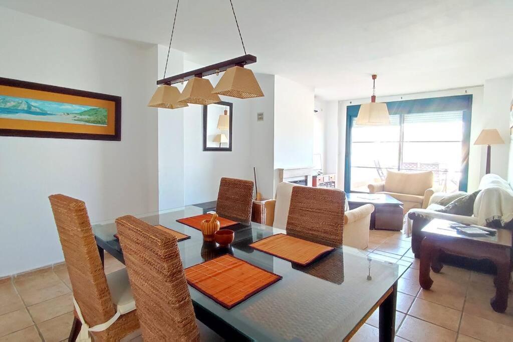 een woonkamer met een eettafel met stoelen bij Terraza con vistas en Alcaidesa in Alcaidesa