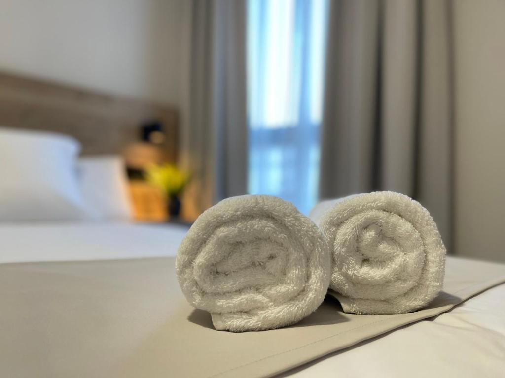 a pair of towels sitting on top of a bed at URBAN Pensión in Melide