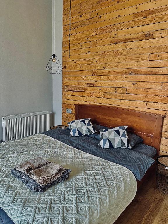 a bedroom with a large bed with a wooden wall at Apart27 in Lviv