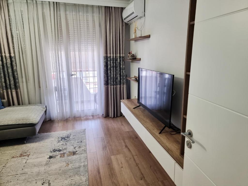 Il comprend un salon doté d'une télévision à écran plat et d'un canapé. dans l'établissement Hera's Home, à Tirana