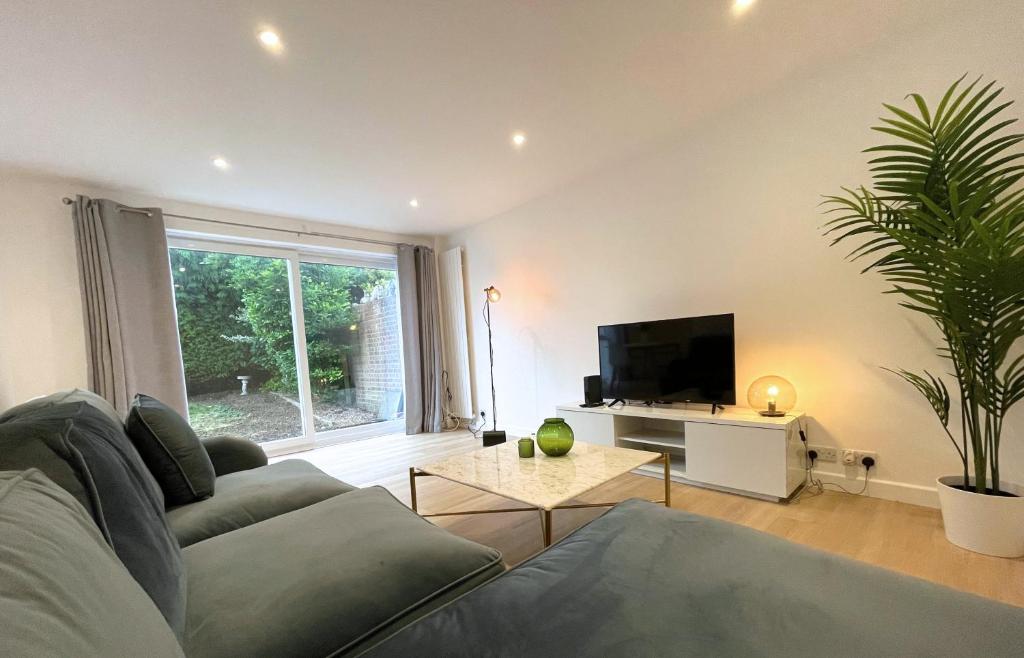 a living room with a couch and a tv at Contemporary-styled 3-Bed House in Buckinghamshire