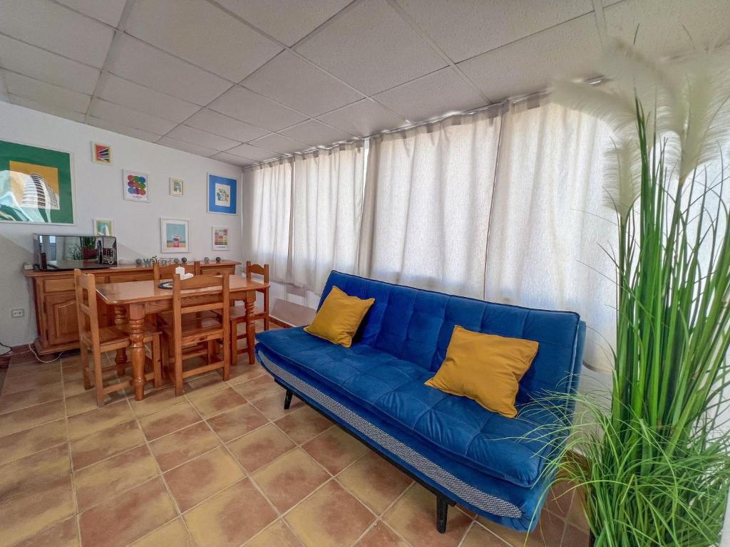 sala de estar con sofá azul y mesa en BeniSol tu hogar en Benidorm en Benidorm
