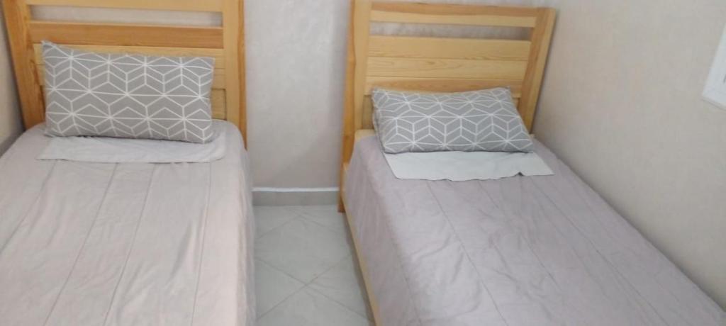 two beds in a small room at Al Hoceima Badess in Al Hoceïma