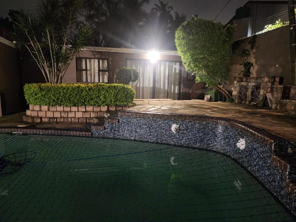 a house with a swimming pool at night at Charles Court Guest House in Durban