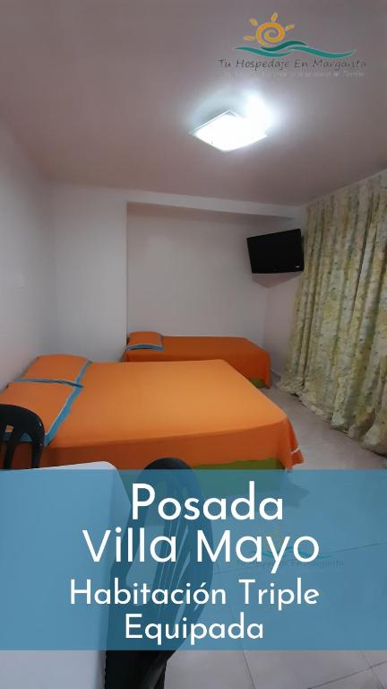 a bedroom with an orange bed and a tv at Habitación Triple Equipada, Posada Villa Mayo a 5 minutos de Playa Parguito in Loma de Guerra