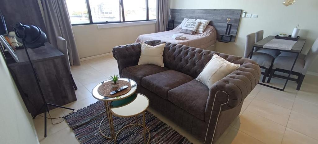 sala de estar con sofá y cama en Elegante Estudio Nordelta Bay , Piscina, Parking en Tigre