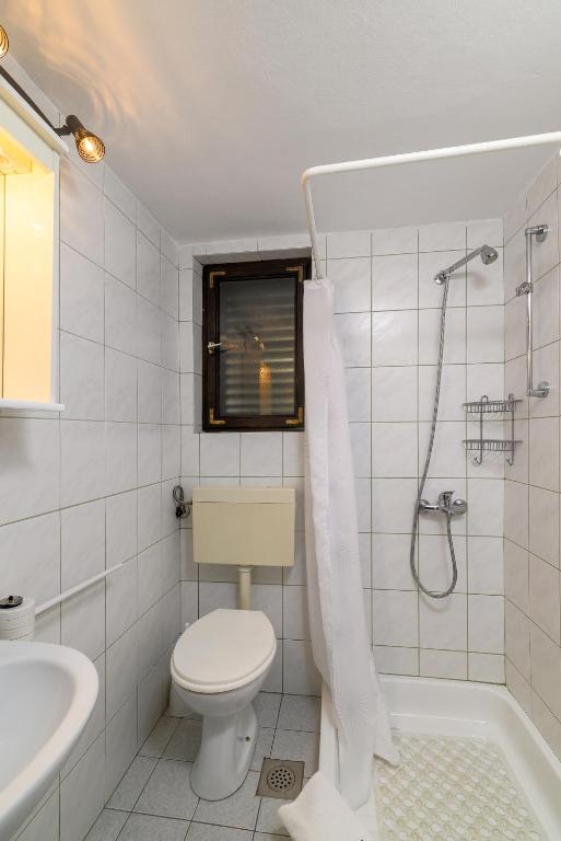 biała łazienka z toaletą i prysznicem w obiekcie Apartments with a parking space Kavran, Marcana - 14109 w mieście Kavran