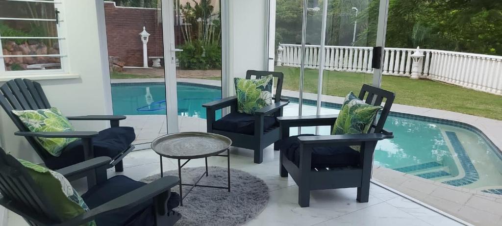 d'une terrasse avec des chaises et une table à côté de la piscine. dans l'établissement Villa Le Rosa Unit 3, à Durban