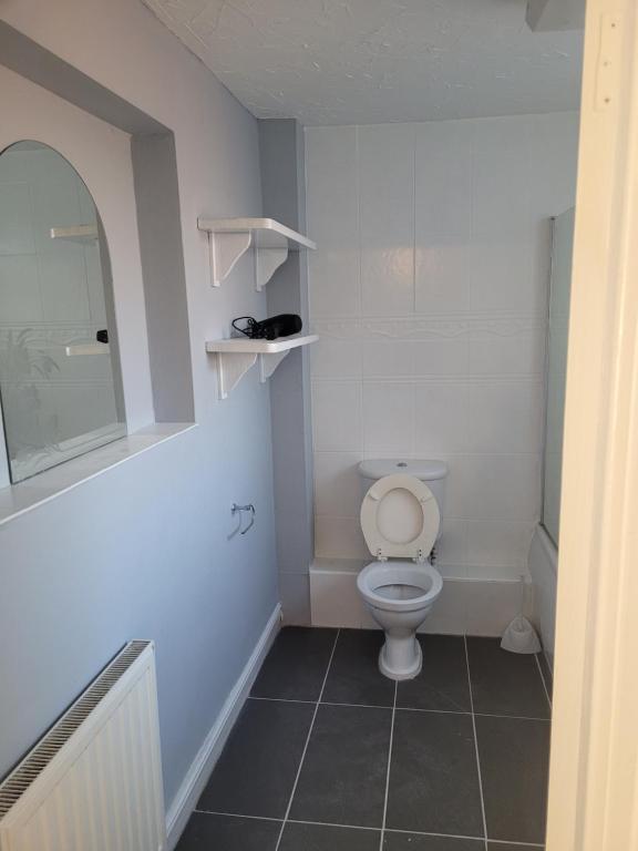a white bathroom with a toilet and a mirror at Decent Homes No 4- modern double room in Dukinfield