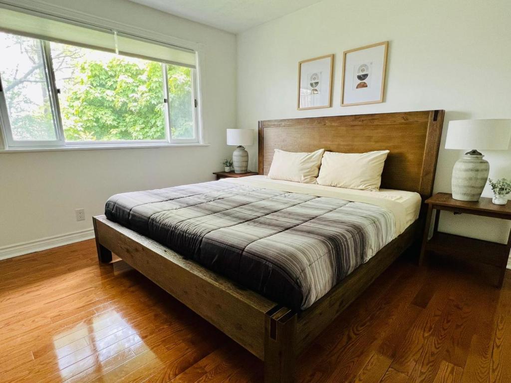 a bedroom with a large bed and a window at Letitia Heights !F Spacious and Stylish Private Bedroom with Shared Bathroom in Barrie