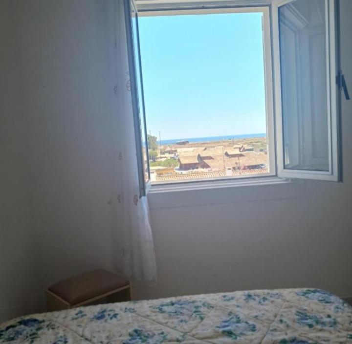 1 dormitorio con ventana y vistas a la playa en Homem de Ferro en Alvor