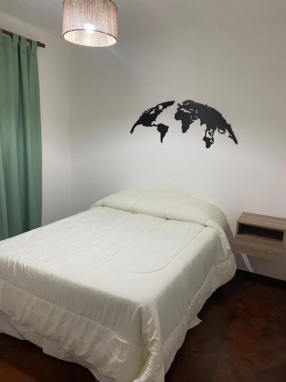 een slaapkamer met een bed met een zwart voorwerp aan de muur bij Dos22 Apartment in Mendoza