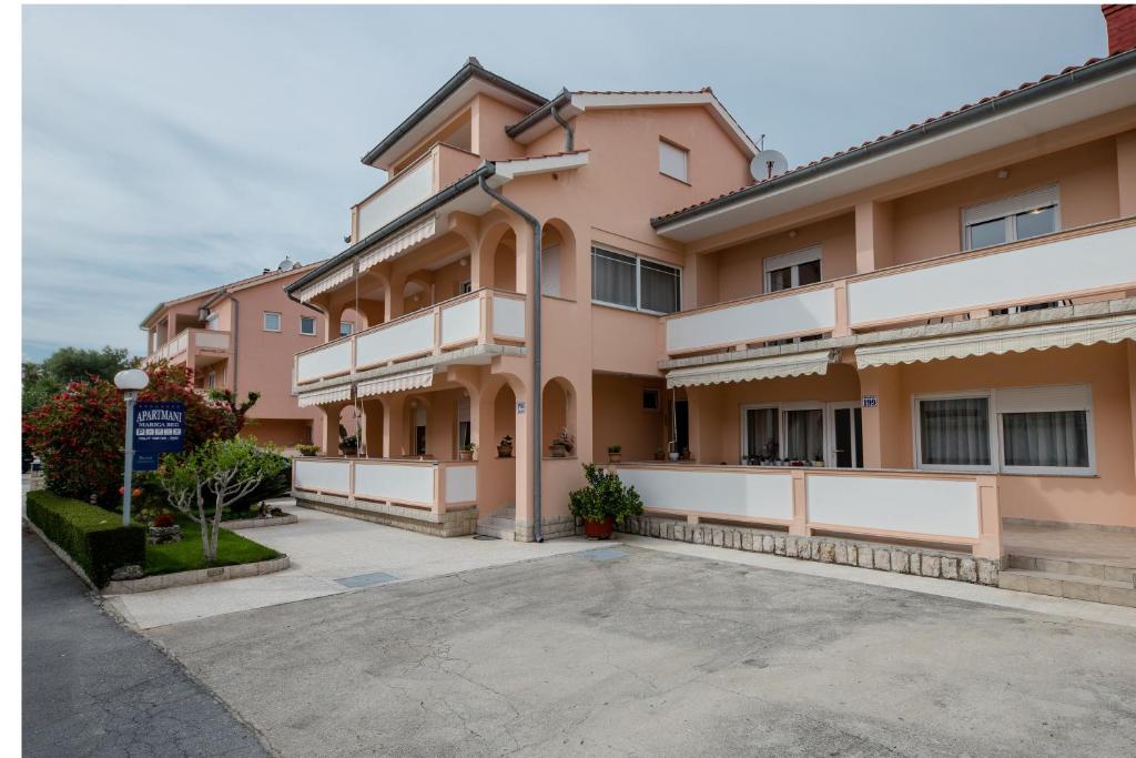 ラブにあるApartments with parking space Palit, Rab - 4970の駐車場付き大ピンクの建物