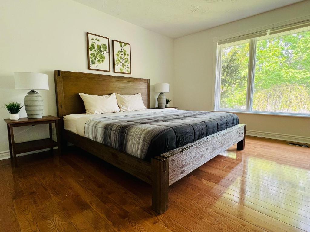 a bedroom with a large bed and a large window at Letitia Heights !G Stylish and Spacious Private Bedroom with Shared Bathroom in Barrie