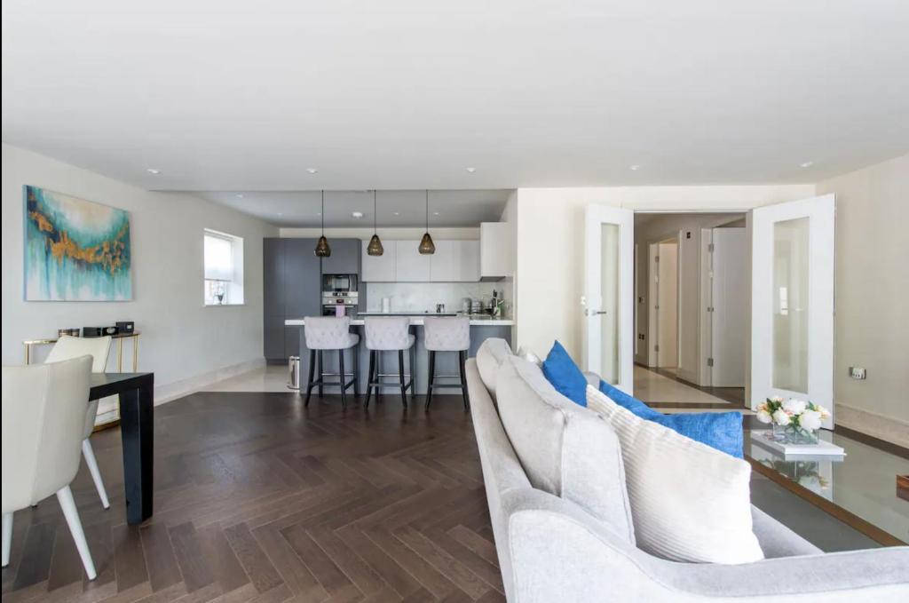 a living room and kitchen with a couch and a table at 2BD, 2BA Urban Oasis in Chigwell