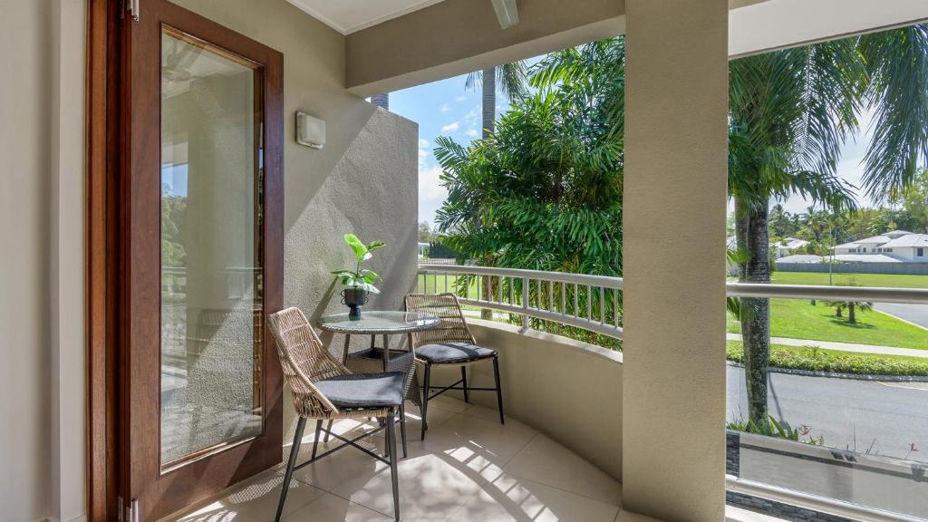 een balkon met een tafel en stoelen en uitzicht bij Watermark Villa Port Douglas in Port Douglas