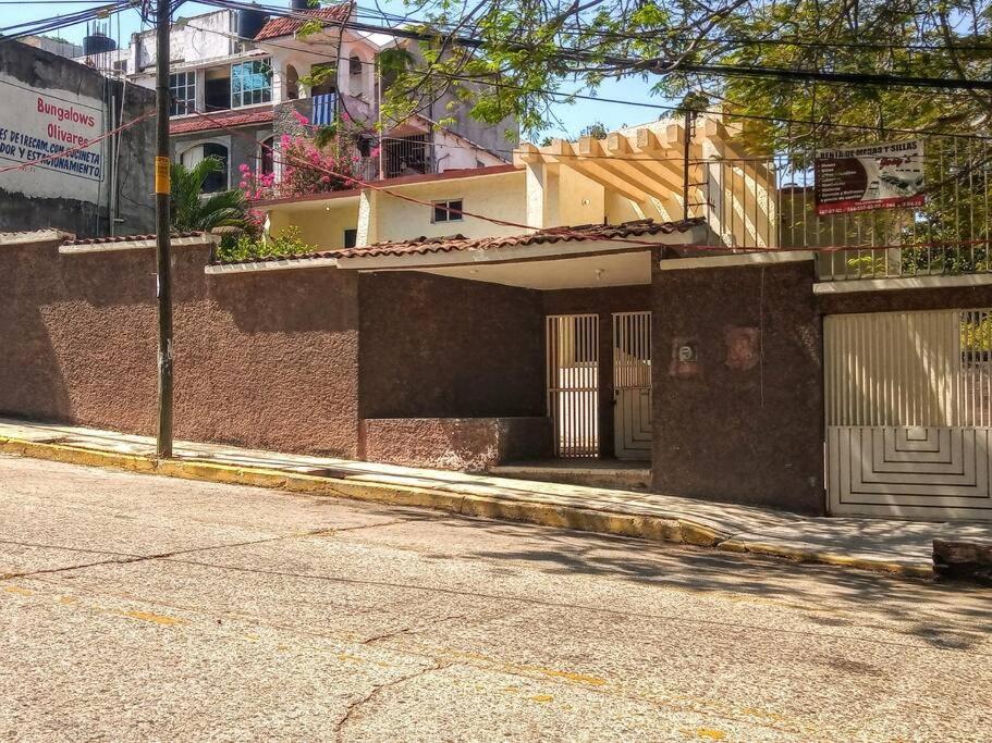 a brick building with a garage on a street at Casa Caleta renta para Vacaciones a 10minplaya in Acapulco