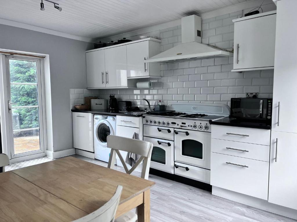 a kitchen with white appliances and a wooden table at Near London Private House FortView Ancient Roman Trail in Gravesend