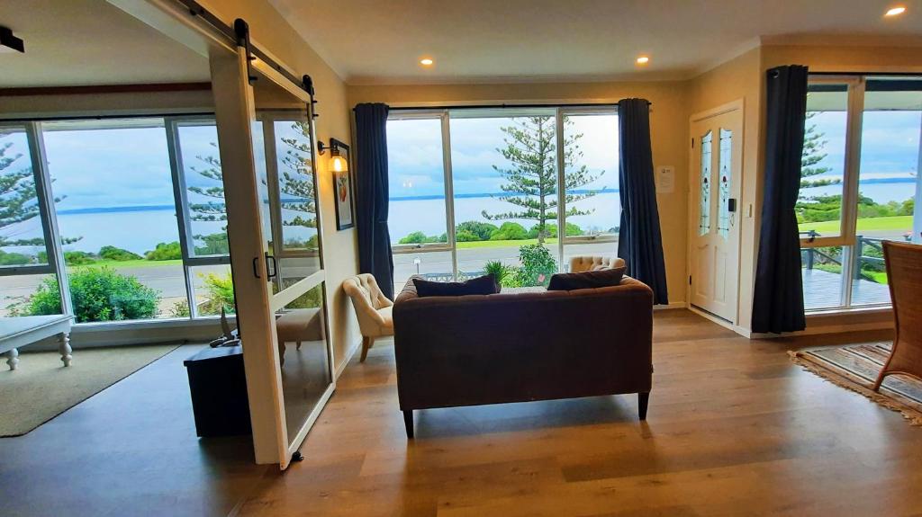 a living room with a couch and large windows at Captains on-the-seafront - stunning sea views- 4br 2bth - large waterfront house in Kingscote