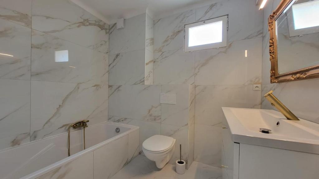 a white bathroom with a toilet and a sink at New two bedroom apartment with AC by the sea in Nice